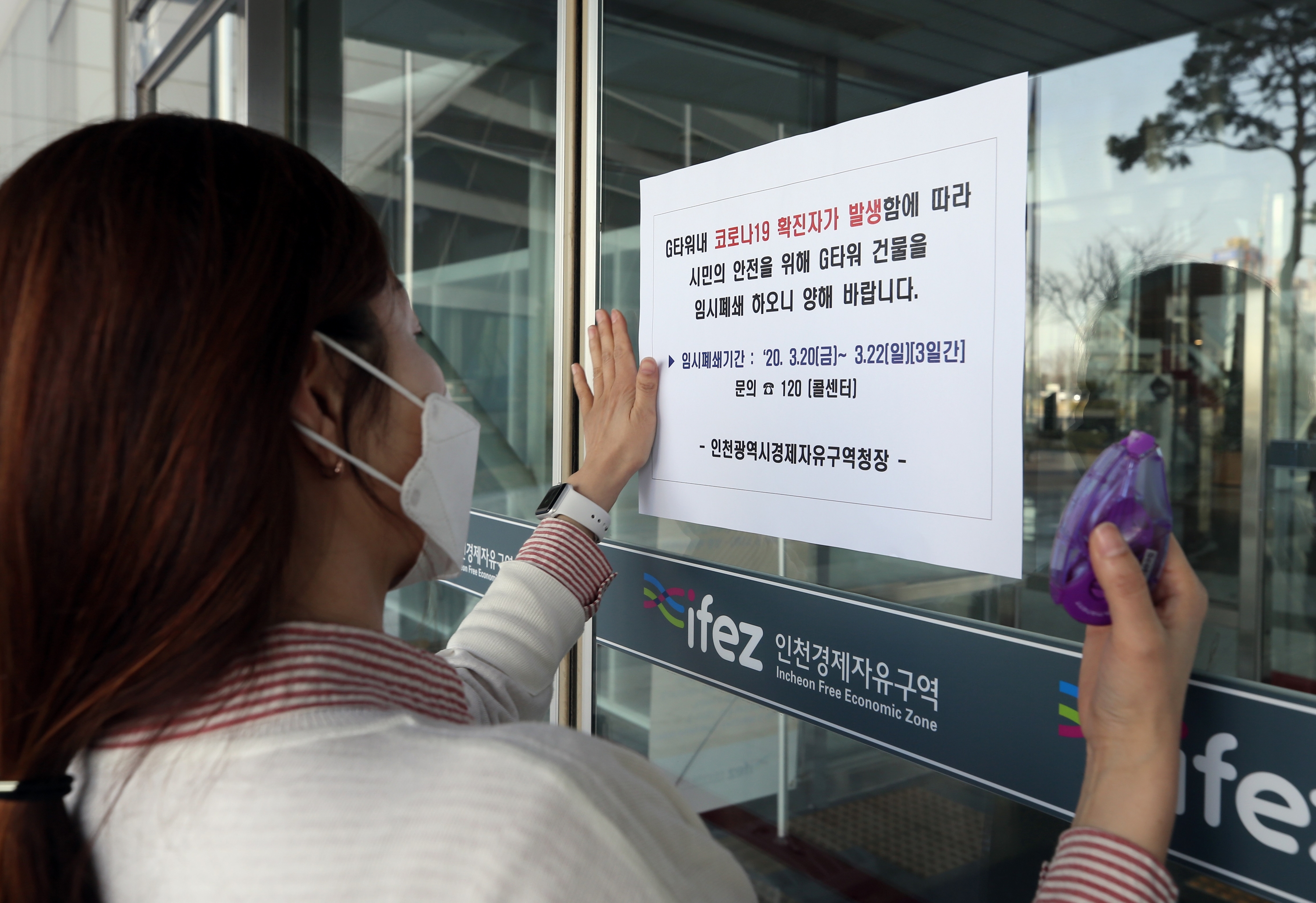 인천경제자유구역청 직원이 20일 G타워 정문 출입구에 일시 폐쇄를 알리는 안내문을 부착하고 있다.<br>