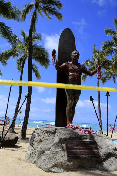 카하나모쿠 공작 동상이 20일(현지시간) 미국 하와이주 호놀룰루의 와이키키 해변에서 노란색 경고 테이프로 둘러싸여 있다. 호놀룰루는 코로나바이러스의 확산을 막기 위해 모든 공원과 휴양지를 폐쇄했다. AP 연합뉴스