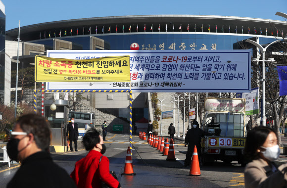 코로나19 집단감염 방지를 위해 정부가 종교 집회 등 밀집 행사 중단을 강력히 권고했음에도 불구하고 22일 예배를 강행한 구로구 연세중앙교회 앞에 교회 관계자들이 입장하는 신자들을 기다리고 있다. 2020.3.22  연합뉴스