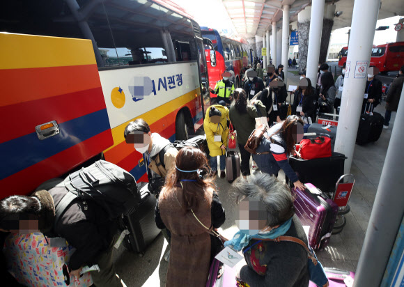 유럽에서 국내로 들어오는 입국자에 대한 검역 절차가 강화된 22일 오후 인천국제공항 1터미널에서 독일 프랑크푸르트발 여객기를 타고 입국한 승객들이 진단 검사를 받는 곳으로 이동하는 차량으로 향하고 있다. 2020.3.22  연합뉴스
