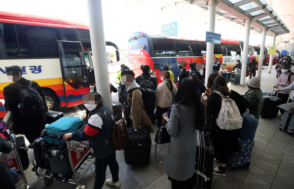 유럽에서 국내로 들어오는 입국자에 대한 검역 절차가 강화된 22일 오후 인천국제공항 1터미널에서 독일 프랑크푸르트발 여객기를 타고 입국한 승객들이 진단 검사를 받는 곳으로 이동하는 차량으로 향하고 있다. 2020.3.22  연합뉴스
