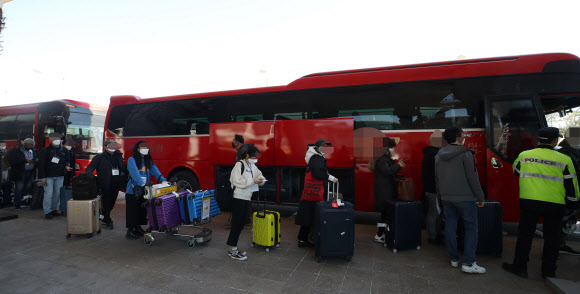 유럽에서 국내로 들어오는 입국자에 대한 검역 절차가 강화된 22일 오후 인천국제공항 1터미널에서 독일 프랑크푸르트발 여객기를 타고 입국한 승객들이 진단 검사를 받는 곳으로 이동하는 차량으로 향하고 있다.   2020.3.22  연합뉴스