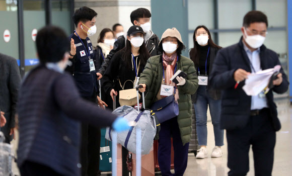 유럽에서 국내로 들어오는 입국자에 대한 검역 절차가 강화된 22일 오후 인천국제공항 1터미널에서 독일 프랑크푸르트발 여객기를 타고 입국한 승객들이 진단 검사를 받는 곳으로 이동하는 차량으로 향하고 있다. 2020.3.22  연합뉴스