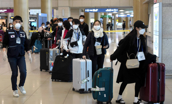 유럽에서 국내로 들어오는 입국자에 대한 검역 절차가 강화된 22일 오후 인천국제공항 1터미널에서 독일 프랑크푸르트발 여객기를 타고 입국한 승객들이 진단 검사를 받는 곳으로 이동하는 차량으로 향하고 있다. 2020.3.22  연합뉴스