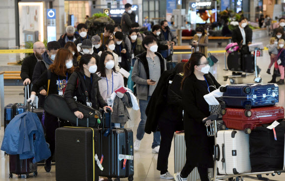 유럽에서 국내로 들어오는 입국자에 대한 검역 절차가 강화된 22일 오후 인천국제공항 1터미널에서 독일 프랑크푸르트발 여객기를 타고 입국한 승객들이 진단 검사를 받는 곳으로 이동하는 차량으로 향하고 있다. 2020.3.22  연합뉴스