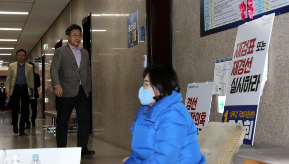 더불어민주당 윤호중 사무총장과 이근형 전략기획위원장이 22일 오후 서울 여의도 국회 당 대표실에서 열린 기자간담회에 참석하고 있다.  앞은 공천무효 농성을 계속중인 유승희 의원.  2020.3.22  연합뉴스