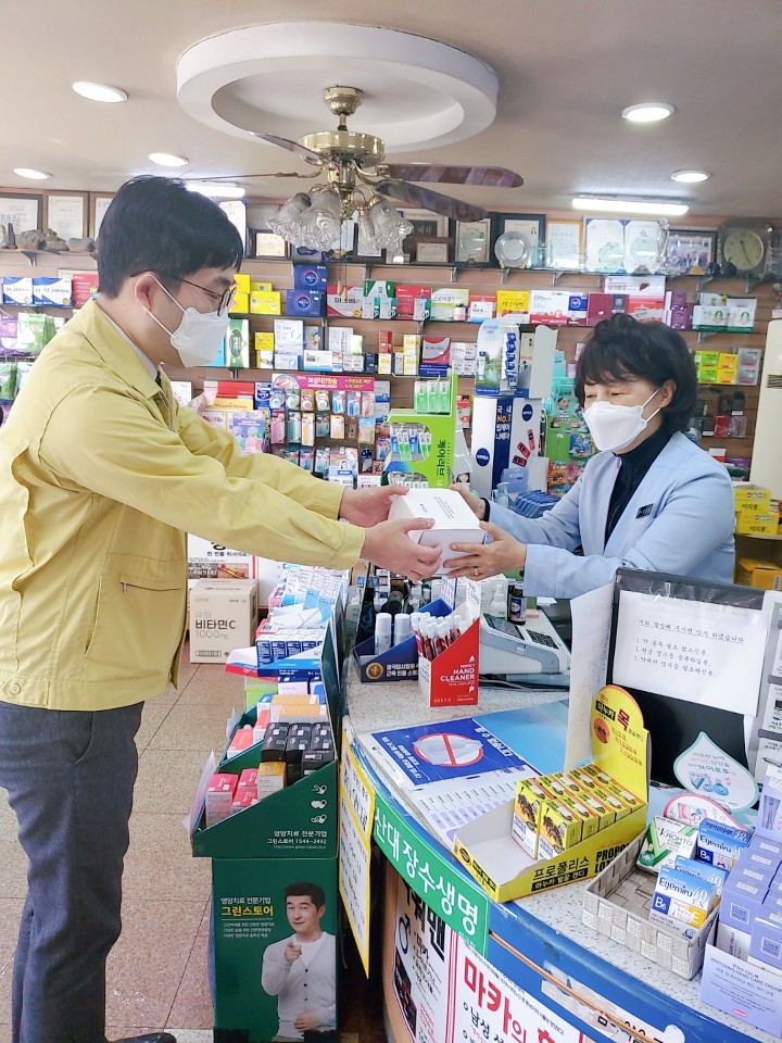 부산시 총무과 직원이 23일 오전 코로나19 확산 방지를 위해 공적 마스크를 공급하는 약사에게 드립팩 커피를 전달하고 있다 <부산시 제공>.