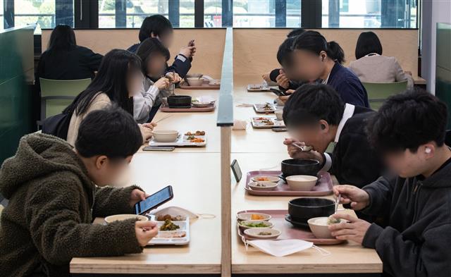 신종 코로나바이러스 감염증(코로나19)이 확산되고 있는 가운데 23일 서울시내 한 대학교 학생식당에서 학생들이 칸막이를 앞에 두고 점심식사를 하고 있다. 2020.3.23 뉴스1