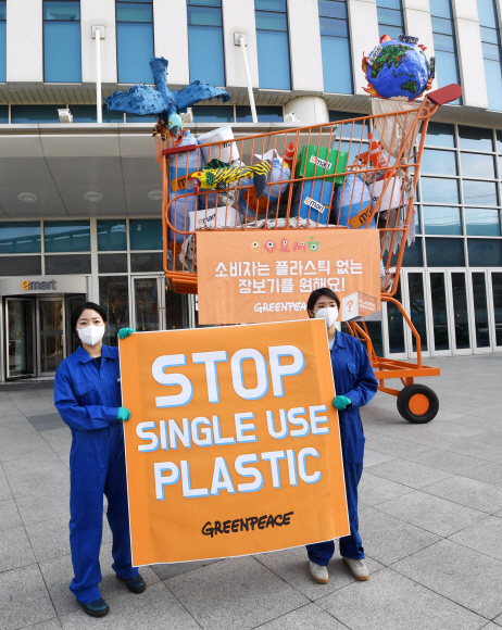26일 서울 성수동 이마트 본사 앞에서 그린피스가 플라스틱 쓰레기로 가득 찬 높이 5m짜리 대형 카트를 설치해 퍼포먼스를 하고 있다. 그린피스 서울사무소는 지난 2월 18일부터 ‘플라스틱 문제 해결을 위해 나서줬으면 하는 마트’를 선정하는 온라인 시민 투표를 진행했다. 그 결과 이마트, 홈플러스, 롯데마트, 하나로마트, 메가마트 등 5대 대형마트 중 이마트가 58%의 득표율로 1위로 선정되었다. 그린피스는 불필요한 일회용 플라스틱 포장재를 없애기 위해, 국내 대형마트에 플라스틱 감축 목표를 세우고 이를 투명하게 공개할 것을 요구했다. 2020.3.26  오장환 기자 5zzang@seoul.co.kr