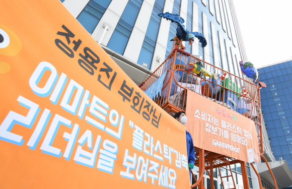 26일 서울 성수동 이마트 본사 앞에서 그린피스가 플라스틱 쓰레기로 가득 찬 높이 5m짜리 대형 카트를 설치해 퍼포먼스를 하고 있다. 그린피스 서울사무소는 지난 2월 18일부터 ‘플라스틱 문제 해결을 위해 나서줬으면 하는 마트’를 선정하는 온라인 시민 투표를 진행했다. 그 결과 이마트, 홈플러스, 롯데마트, 하나로마트, 메가마트 등 5대 대형마트 중 이마트가 58%의 득표율로 1위로 선정되었다. 그린피스는 불필요한 일회용 플라스틱 포장재를 없애기 위해, 국내 대형마트에 플라스틱 감축 목표를 세우고 이를 투명하게 공개할 것을 요구했다. 2020.3.26  오장환 기자 5zzang@seoul.co.kr