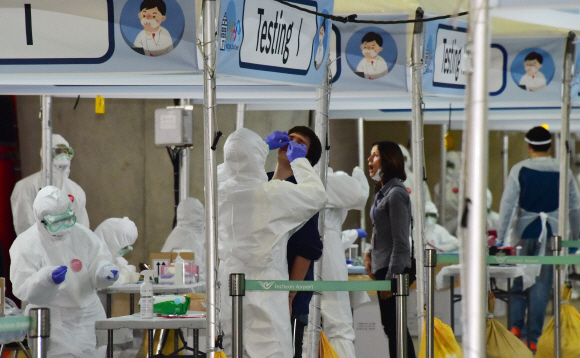 코로나19가 미국,유럽등으로 급속도로 확산되고 있는  방역당국이 국내입국 외국인들의 코로나19 전수조사를 시작한 26일 영국 런던발 항공기에서 내린 외국인승객들이 인천국제공항 제2터미널 외부에 차려진 개방형 선별진료소에서 검사를 받고 있다. 2020.3.26.    이종원 선임기자 jongwon@seoul.co.kr