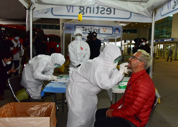 코로나19가 미국,유럽등으로 급속도로 확산되고 있는  방역당국이 국내입국 외국인들의 코로나19 전수조사를 시작한 26일 영국 런던발 항공기에서 내린 외국인승객들이 인천국제공항 제2터미널 외부에 차려진 개방형 선별진료소에서 검사를 받고 있다. 2020.3.26.    이종원 선임기자 jongwon@seoul.co.kr