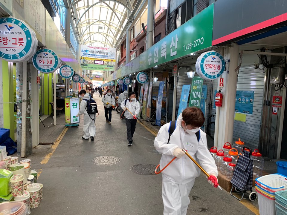 서울 광진구 자양동 주민센터 직원들이 노룬산시장을 방역하고 있는 모습. 2020.3.28. 광진구 제공