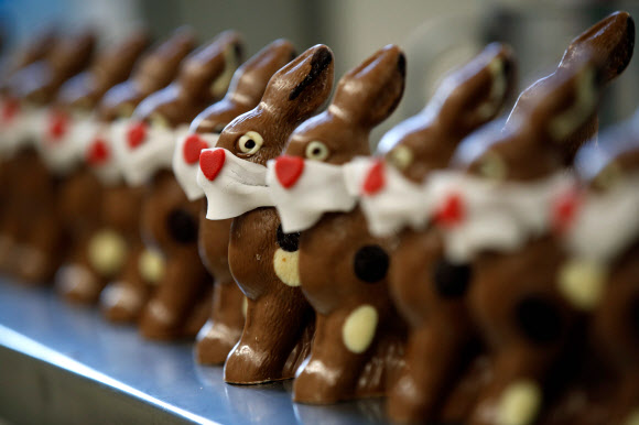 세계적으로 신종 코로나바이러스(코로나19)의 확산이 계속되고 있는 가운데 27일(현지시간) 스위스 베른에 있는 한 베이커리에서 마스크를 쓴 부활절 토끼 초콜릿을 만들고 있다.  AFP 연합뉴스
