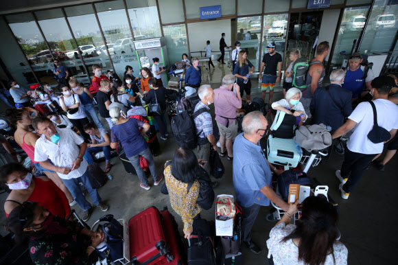 신종 코로나바이러스 감염증(코로나19) 확산에 따른 항공편 운항 중단으로 여행객들이 필리핀에서 발이 묶인 가운데 28일(현지시간) 마닐라의 니노이 아키노 국제공항에서 독일인들이 귀국 전세기를 기다리고 있다.  EPA 연합뉴스