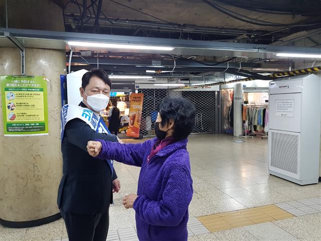 서울 송파을 더불어민주당 최재성(왼쪽) 후보가 1일 리모델링 공사가 진행 중인 잠실새내역에서 주민과 팔뚝 인사를 나누고 있다. 신융아 기자 yashin@seoul.co.kr