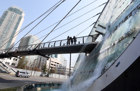 2일 서울 서초구 예술의전당에서 양재역 방면에 있는 아쿠아아트육교의 워터스크린 앞을 시민들이 걷고 있다. 워터스크린은 10월 말까지 출근, 점심, 퇴근시간대에 가동한다. 2020.4.2  박윤슬 기자 seul@seoul.co.kr