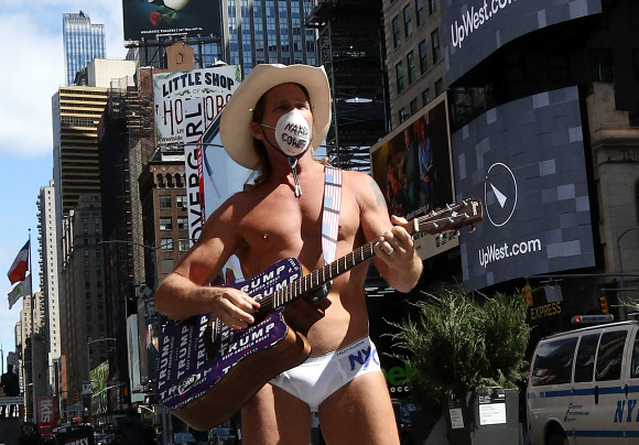 미국에서도 뉴욕주에서 가장 코로나19로 인한 피해가 집중되는 가운데 2일(현지시간) 뉴욕에서 가장 번화했던 타임스퀘어에서 거의 벌거벗은 채 마스크를 쓴 카우보이 남성이 텅 빈 거리를 배경으로 노래를 들려주고 있다. 뉴욕 AFP 연합뉴스 