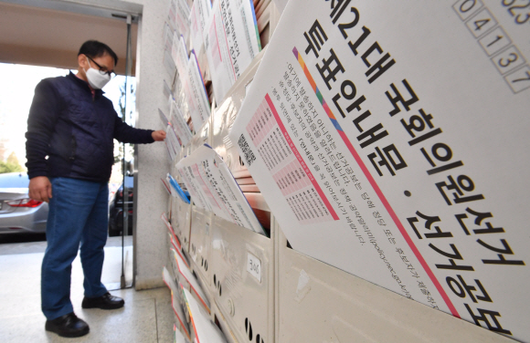 투표안내문과 선고공보가 유권자에게 배송된 5일 서울 마포구의 한 아파트에서 시민이 우편물을 살펴보고 있다. 2020.4.5 박지환기자 popocar@seoul.co.kr