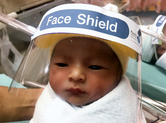 3일(현지시간) 태국 사뭇프라칸의 파올로 병원에서 한 간호사가 신생아에게 코로나바이러스로부터 보호하기 위해 얼굴 보호막을 씌워주고 있다. AP 연합뉴스