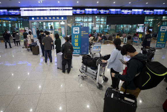 6일 오전 특별기편으로 귀국한 인도 뉴델리 지역 교민 220여명 등을 비롯한 입국자들이 인천국제공항 2터미널에서 버스 탑승을 위해 줄을 서 있다. 2020.4.6  연합뉴스