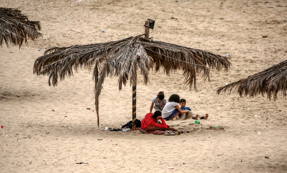 코로나19 대유행이 계속되고 있는 가운데, 팔레스타인인들이 5일(현지시간) 가자시티 해변에 앉아 있다. EPA 연합뉴스