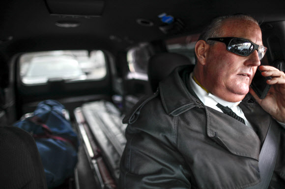미국 뉴욕의 장의업자 톰 치스먼이 지난 3일(현지시간) 브루클린 지구에서 시신이 안치된 관을 운구차 뒤쪽에 실은 뒤 통화하고 있다. 뉴욕 AP 연합뉴스 