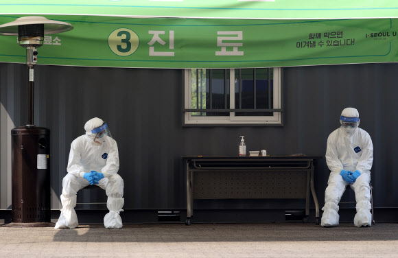 7일 오전 서울 송파구 잠실종합운동장 주경기장에 설치된 신종 코로나바이러스(코로나19) 드라이브 스루 선별진료소에서 의료진이 의자에 앉아 잠시 쉬고 있다. 2020.4.7  연합뉴스