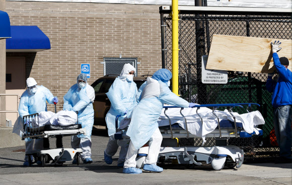 미국 의료진이 6일 뉴욕 브루클린의 임시 시체안치소에서 코로나19 사망자 시신을 옮기고 있다. 연합뉴스