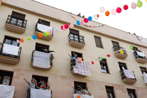 신종 코로나바이러스 감염증(코로나19) 확산으로 스페인에서 외출규제가 이어지고 있는 가운데 론다 지역에 거주하는 한 커플이 프러포즈 이벤트를 벌여 이웃들이 이를 축하하고 있다. 로이터 연합뉴스