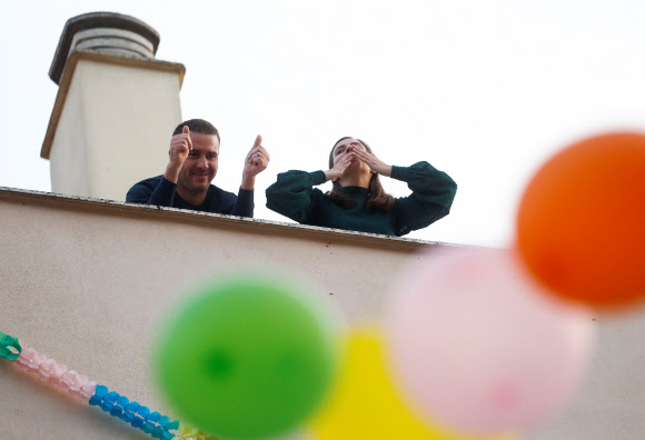 신종 코로나바이러스 감염증(코로나19) 확산으로 스페인에서 외출규제가 이어지고 있는 가운데 론다 지역에 거주하는 한 커플이 프러포즈 이벤트를 벌여 이웃들이 이를 축하하고 있다. 로이터 연합뉴스