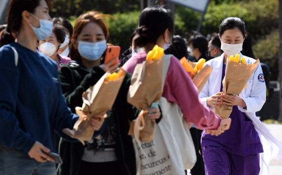 8일 서울 중랑구 서울의료원에서 의료진들이 튤립 꽃다발을 선물 받은 후 즐거워하고 있다. 주한네덜란드대사관에서 서울의료원 의료진에게 감사의 메시지를 전달하기 위해 튤립 7천송이(꽃다발 1000개)를 준비했다고 서울의료원은 밝혔다. 2020. 4.8 박윤슬 기자 seul@seoul.co.kr