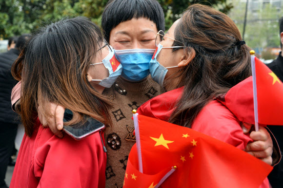 의료진이 10일(현지시간) 중국 동부 안후이성 보저우에서 COVID-19 코로나바이러스 복구 작업을 마치고 우한에서 귀국한 후, 친척과 키스를 나누고 있다. AFP 연합뉴스