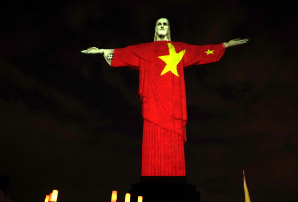 12일(현지시간) 브라질 리우데자네이루의 예수상에 부활절을 맞아 신종 코로나바이러스 감염증(코로나19)과 싸우고 있는 각국의 국기가 비치고 있다. AP 연합뉴스