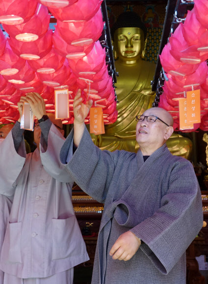 조계사 주지 지현 스님(오른쪽)과 남전 스님이 불기 2564년 부처님 오신 날을 보름 정도 앞둔 14일 서울시 종로구 조계사 대웅전에서 올해 대웅전 연등 이름표를 달고 있다. 대한불교조계종은 올해 부처님 오신 날 행사를 코로나19 때문에 한 달 늦춰 음력 윤달 4월 초파일인 5월 30일 개최한다. 2020.4.14  연합뉴스