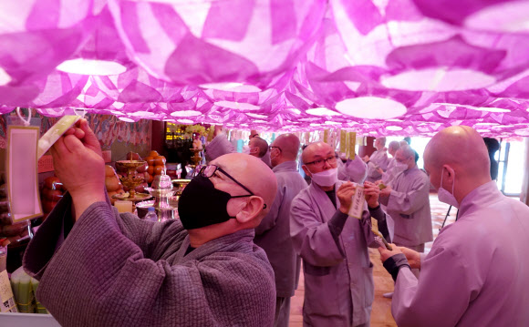 조계사 주지 지현 스님(왼쪽 첫 번째)과 남전 스님(가운데) 등 스님들이 불기 2564년 부처님 오신 날을 보름 정도 앞둔 14일 서울시 종로구 조계사 대웅전에서 올해 대웅전 연등 이름표를 달고 있다. 대한불교조계종은 올해 부처님 오신 날 행사를 코로나19 때문에 한 달 늦춰 음력 윤달 4월 초파일인 5월 30일 개최한다. 2020.4.14  연합뉴스