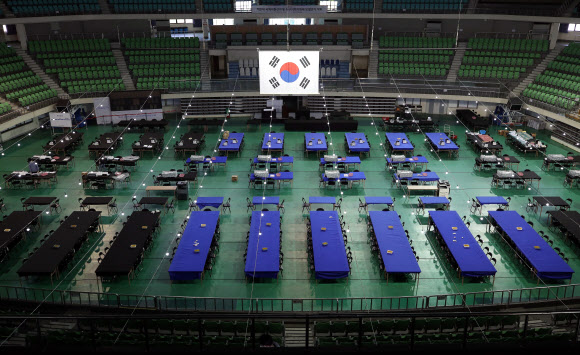 4.15 총선 투표일을 하루 앞둔 14일 오후 대구시 북구 산격동 대구체육관에 마련된 개표소에서 관계자들이 개표소 준비 마무리 작업을 하고 있다. 태극기는 뒷면의 모습이다. 2020.4.14  연합뉴스