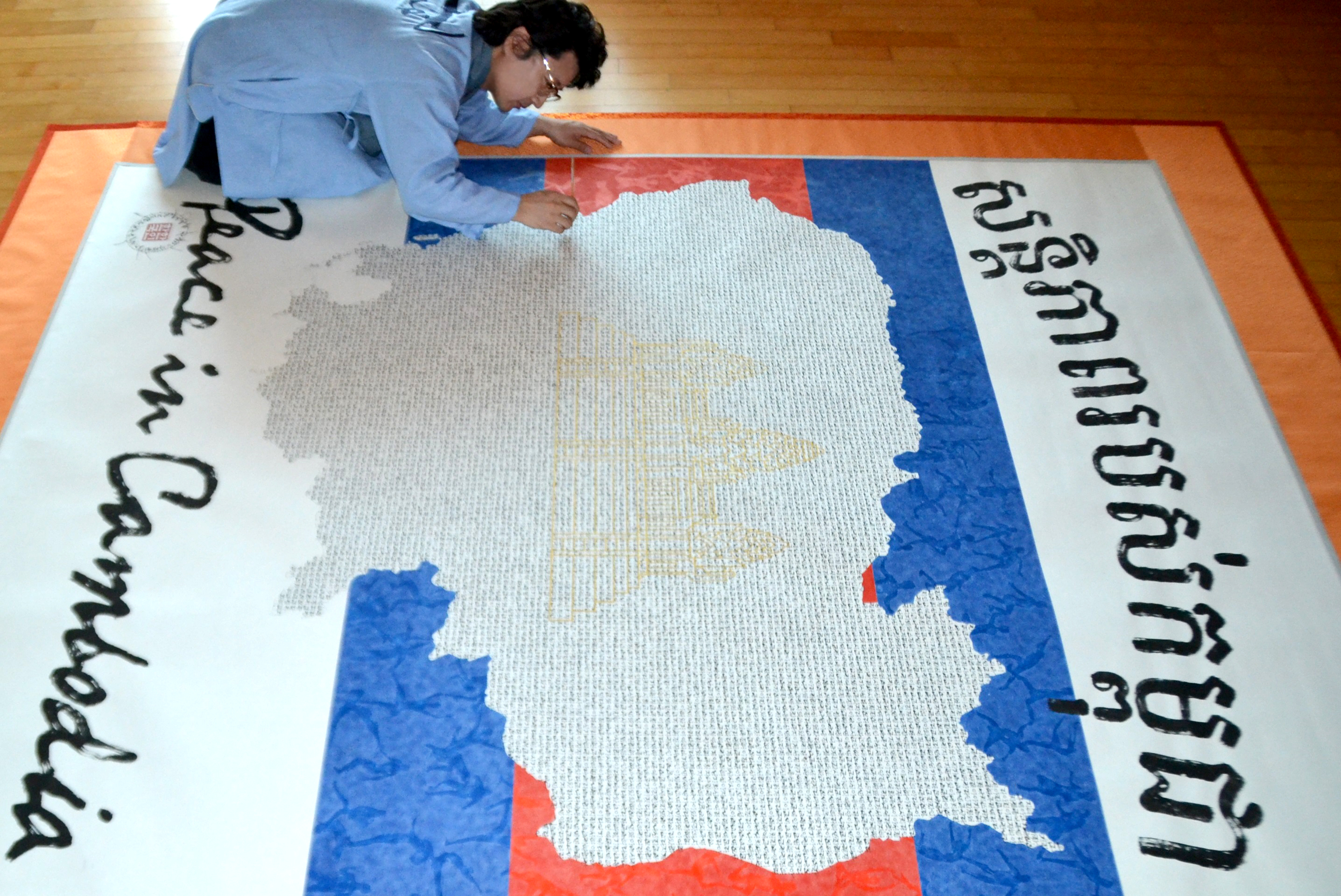 한한국 세계평화작가가 한글 세필붓글씨 1만 1500자를 캄보디아 평화지도에 새기고 있다.