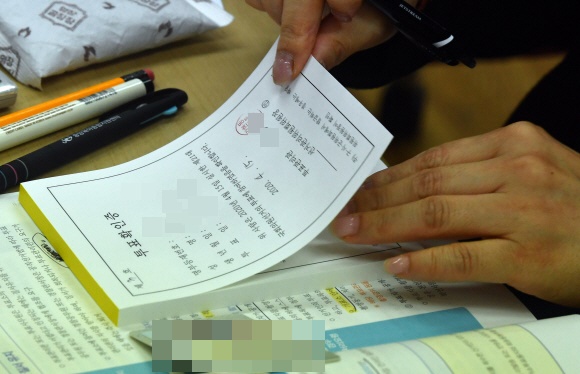 15일 경기도 과천시 갈현동 투표소에서 투표를 마친 시민이 선거확인증을 받고 있다. 2020.4.15 박지환기자 popocar@seoul.co.kr