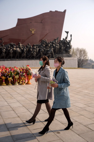 마스크를 쓴 평양 시민들이 15일 김일성 주석의 108회 생일인 태양절을 맞아 김일성 주석의 동상에 헌화하고 있다. AFP 연합뉴스