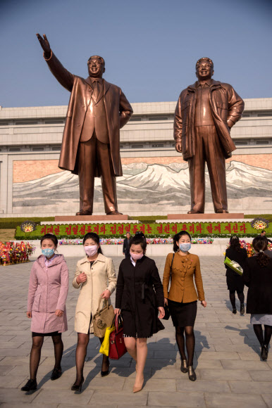 마스크를 쓴 평양 시민들이 15일 김일성 주석의 108회 생일인 태양절을 맞아 김일성 주석의 동상에 헌화한 후 떠나고 있다. AFP 연합뉴스