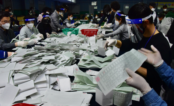 15일 제21대 국회의원 선거의 투표가 끝나자 영등포구선관위 개표소인 영등포다목적배드민턴체육관에서 각 투표소별로 수거해온 투표용지를 개표요원들이 검수 및 확인을 하며 개표작업을 하고 있다. 특히 이번에는 비례대표 출마 정당이 많아서 일일이 수작업을 거쳐야만 했다. 2020.4.15.     이종원 선임기자 jongwon@seoul.co.kr