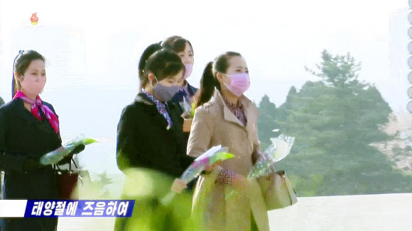 북한은 자신들의 최대 명절 중 하나로 꼽는 김일성 주석의 108회 생일(태양절)인 15일 큰 규모의 기념행사를 생략한 채 조용한 분위기를 이어갔다. 북한이 보통 성대하게 기념하는 5년, 10년 단위로 꺾어지는 이른바 ‘정주년’이 아닌 데다 신종 코로나 바이러스 감염증(코로나19) 여파가 영향을 준 것으로 보인다. 사진은 조선중앙TV가 이날 보도한 마스크를 낀 채 김일성,김정일 동상에 헌화하는 평양 주민들. 2020.4.15  조선중앙TV 화면 캡처=연합뉴스