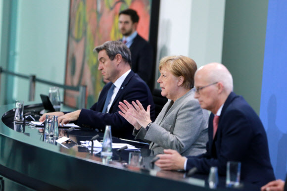 앙겔라 메르켈(가운데) 독일 총리가 15일(현지시간) 베를린 총리실에서 마르쿠스 죄더(왼쪽) 바이에른주 총리, 페터 첸처 함부르크 제1 시장과 코로나19 대응 기자회견을 열어 접촉 제한 조치를 다음달 3일까지 연장하겠다고 발표하고 있다. 베를린 EPA 연합뉴스 