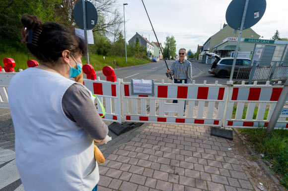 한 독일 시민이 18일(현지시간) 독일과 프랑스 국경에서 코로나 19 감염의 확산을 억제하기 위한 프랑스의 봉쇄에, 벌금을 피하기 위해서 낚시대를 이용해 프랑스 바게트를 받고 있다. AFP 연합뉴스