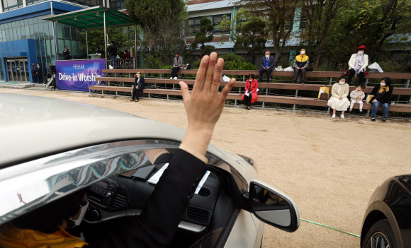 19일 중랑구 서울씨티교회에서 신도들이 주차장에 차를 세운 상태에서 라디오를 통해 목사 설교를 듣는 ‘승차예배’를 하고 있다. 정부는 코로나19 대응 사회적 거리두기 연장 여부를 이날 결정할 예정이다. 2020.4.19  연합뉴스