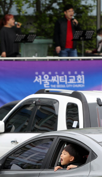 19일 중랑구 서울씨티교회 주차장에서 승차예배에 참석한 한 어린이가 창밖을 보고 있다. 정부는 코로나19 대응 사회적 거리두기 연장 여부를 이날 결정할 예정이다. 2020.4.19  연합뉴스