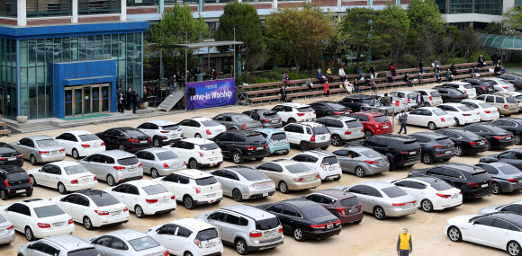 19일 중랑구 서울씨티교회에서 신도들이 주차장에 차를 세운 상태에서 라디오를 통해 목사 설교를 듣는 ‘승차예배’를 하고 있다. 정부는 코로나19 대응 사회적 거리두기 연장 여부를 이날 결정할 예정이다. 2020.4.19  연합뉴스