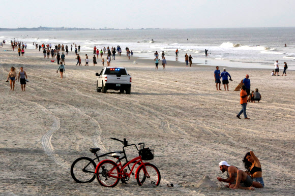 18일(현지시간) 미국 플로리다주 잭슨빌의 듀발 카운티 해변을 재개방하자 수많은 인파가 몰려들어 한가로이 거닐고 있다. 로이터 연합뉴스