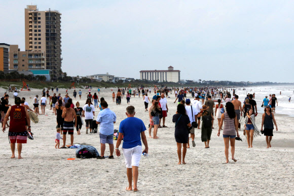 18일(현지시간) 미국 플로리다주 잭슨빌의 듀발 카운티 해변을 재개방하자 수많은 인파가 몰려들어 한가로이 거닐고 있다. 로이터 연합뉴스